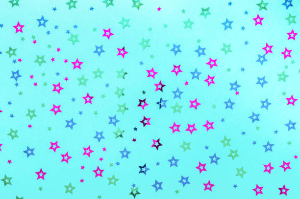 istock Multicolored stars sprinkles on pastel blue backdrop. Festive holiday background. for your projects. Celebration concept. Christmas pattern. Top view, flat lay 1168808060