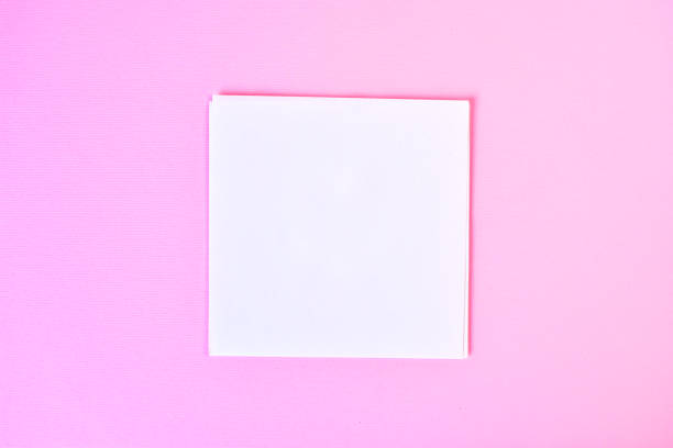 istock Empty white paper on a pink background, as mockup for your design. Minimal composition in flat lay style. 1168811285