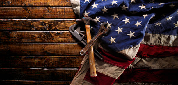 istock Old and worn work tools on large American flag - Labor day background 1168817214