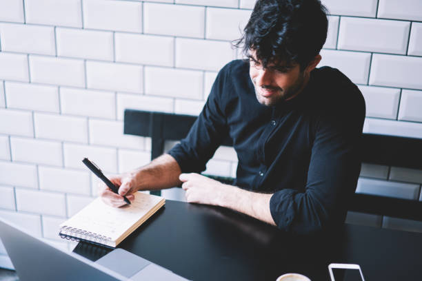 istock Positive student writing down records during watching business webinar on digital netbook device sitting in stylish coffee shop.Cheerful it professional studying during video lessons 1168817260