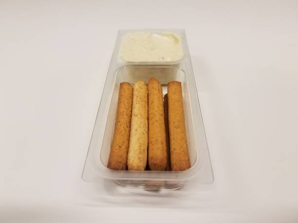 istock bread sticks and cheese spread in plastic container on white desk 1168818854