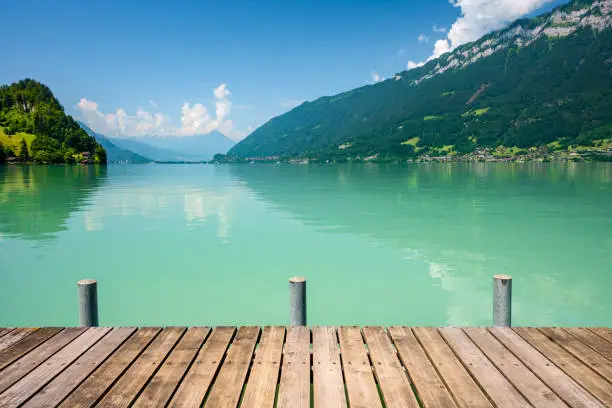 View of Brienz lake with clear turquoise water. Wooden pier. Brienz lake in the village of Iseltwald, Switzerland.