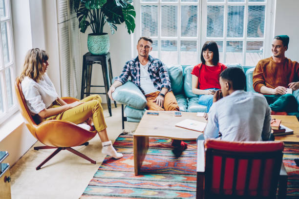 istock Positive multicultural young people dressed in casual apparel spending free time together playing game in modern flat with stylish interior.Cheerful hipsters communicating with each other 1168825286