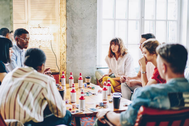 istock Pensive multicultural young people sitting at poker table and plating game using cards and chips sitting in comfortable apartment.Diverse friends spending time together on entertainment 1168825310