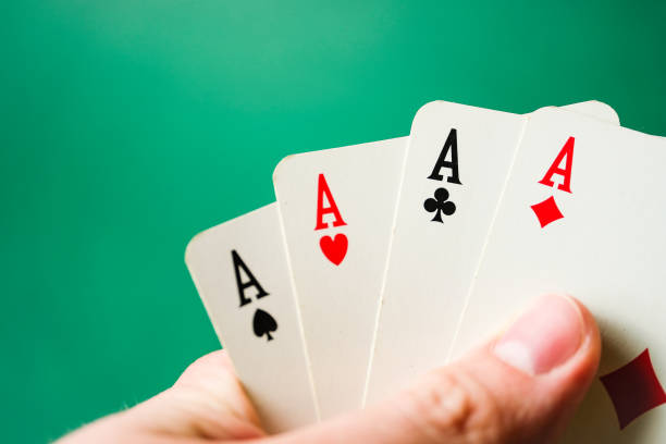 istock Hand holds four aces on a green background. 1168826384
