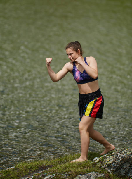 istock Woman kickbox fighter training by the lake 1168828029