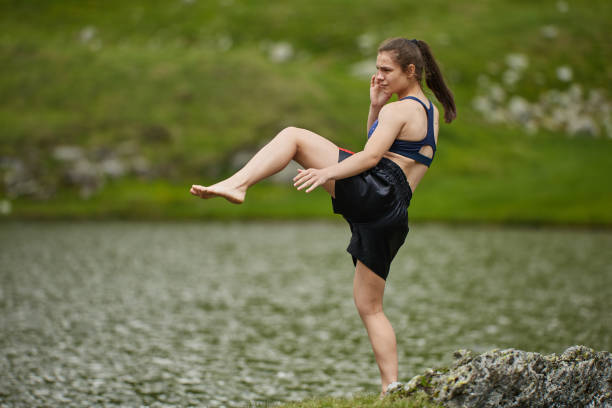 istock Woman kickbox fighter training by the lake 1168828037