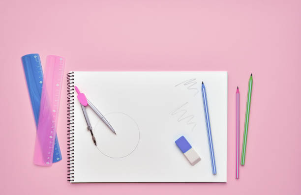 istock Spiral notepad with pencils. Notebook on pastel pink backdrop. Back to school concept. Copy space, top view. 1168828982