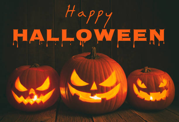 istock Pumpkins carved for Halloween on Rough Wood Table. 1168831189