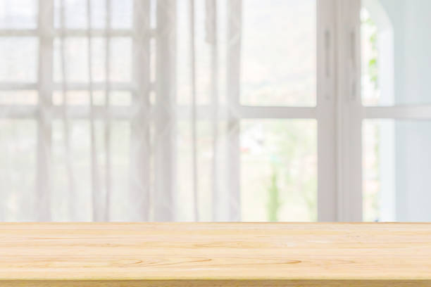istock Empty wood table top with window curtain abstract blur background for product display 1168839877