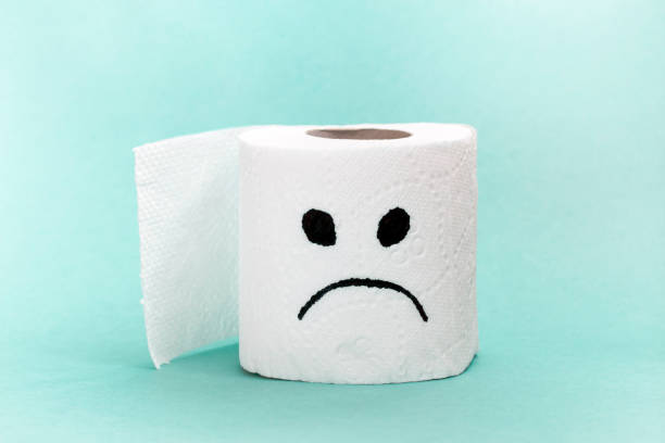 istock White toilet paper with sad face. Creative concept constipation, indigestion, digestion problem. 1168840664