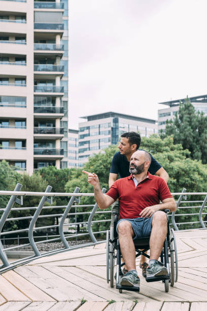 istock man in wheelchair conversing with his friend 1168842096
