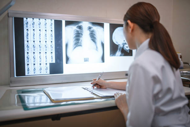 istock Young Japanese Nurse Examining X-Rays and Writing Notes 1168842149