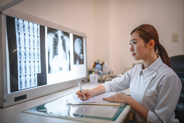 istock Young Female Japanese Nurse Making Notes about X-Rays 1168842157