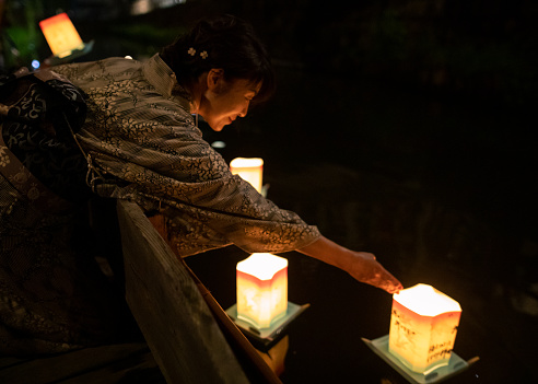 Japanese woman in yukata releasing paper lantern