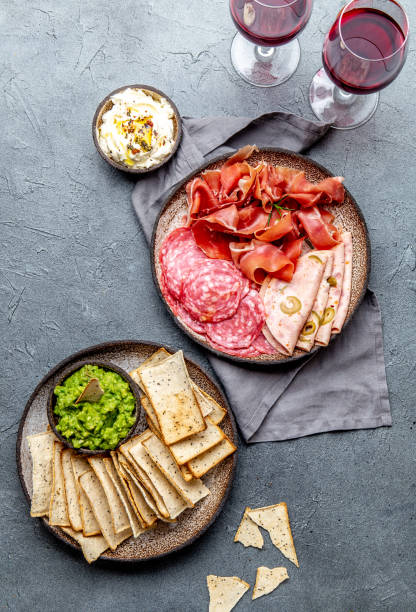 istock Antipasto. Meat platter, chips and sauces, red wine on gray background. Top view 1168843481