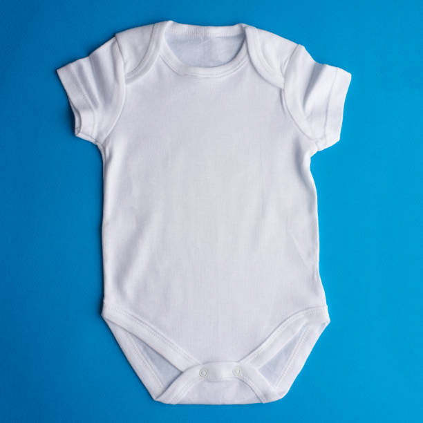 istock Flat Lay a white bodysuit for a child on a purple background. Layout for design and placement of logos, advertising 1168846105