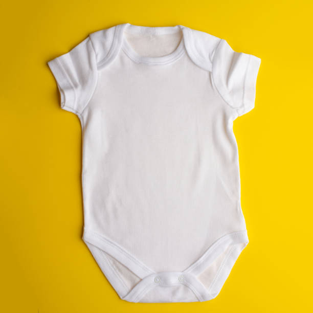 istock Flat Lay a white bodysuit for a child on a yellow background. Layout for design and placement of logos, advertising 1168846625