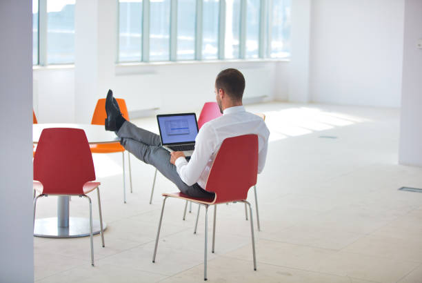 istock Rear view of young businessman using laptop at new office 1168846872