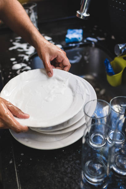 istock A man's hand washes dishes in the sink 1168847812