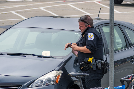 August 10, 2019 San Francisco / CA /USA - US Park Police officer writing a parking ticket in Presidio Park