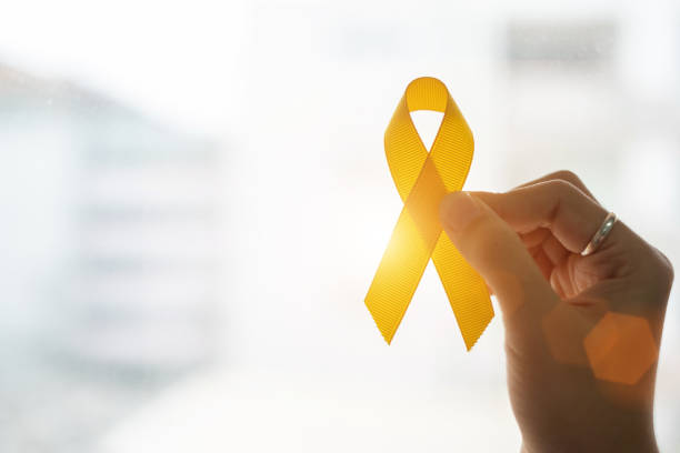 自殺預防和兒童癌症意識，黃絲帶在木背景上支援人們的生活和疾病。兒童醫療保健和世界癌症日概念 - 黃色 個照片及圖片檔