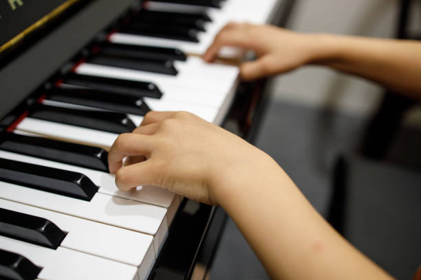 istock Two Small Childent's Hands Playing The Piano 1168858432