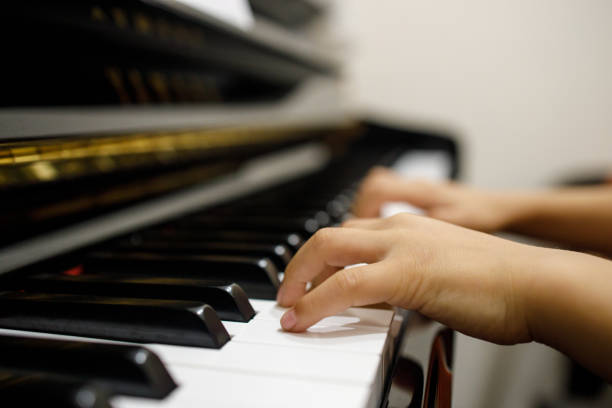 istock Two Small Childent's Hands Playing The Piano 1168858435