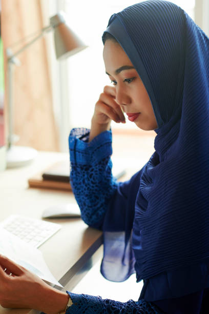 istock Muslim woman reading document 1168869860