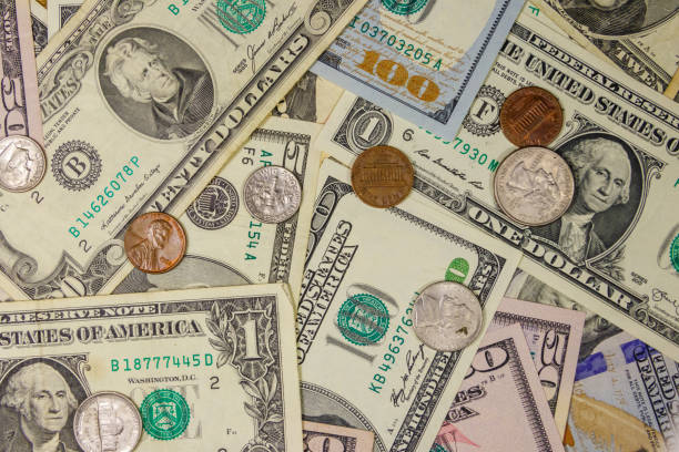 istock Background of different american dollars bills and coins 1168873543