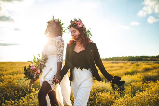 istock Two lesbian brides walking in the yellow flower field 1168883769