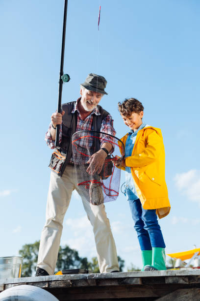 istock Pensioner and grandson smiling after catching fish into net 1168884007