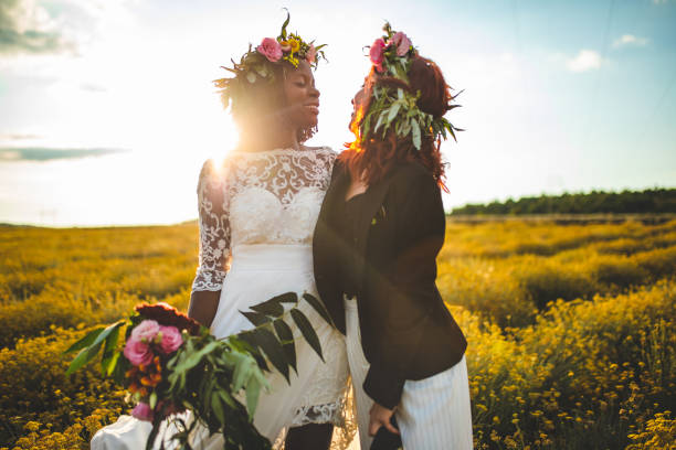 LGTB partners enjoying their special day in love Romantic same sex couple hugging and cuddling on their wedding day, outdoor, on sunny summer day eloping stock pictures, royalty-free photos & images