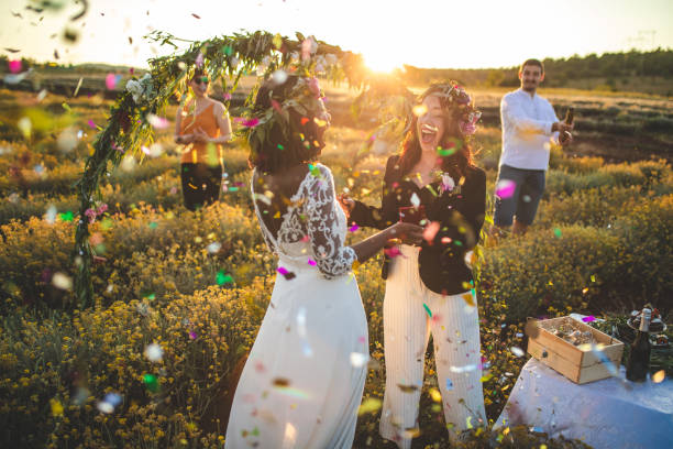 Just married homosexual couple in love Smiling lesbian couple enjoying their wedding ceremony outdoor on sunny day, confetti flying eloping stock pictures, royalty-free photos & images