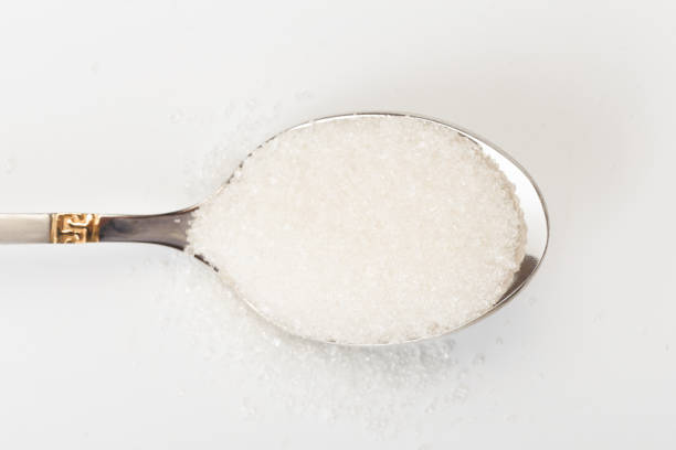 istock Spoon of fine granulated sugar isolated on white 1168889018