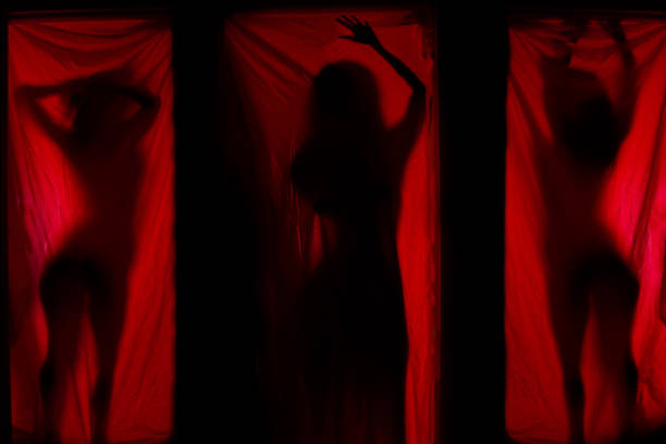 istock Woman behind red curtains 1168889144