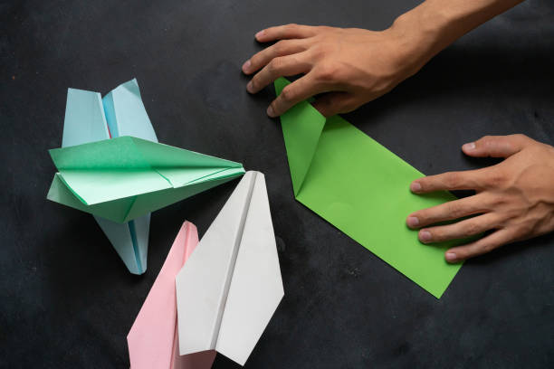 istock person hands making a origami color paper plane 1168889263