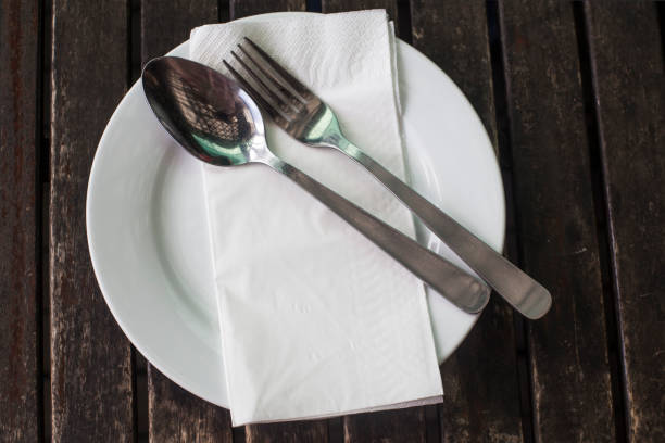 istock Plate, knife and fork on wooden background 1168890079