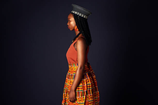 Studio shot of an attractive young woman dressed in traditional african attire posing against a black background