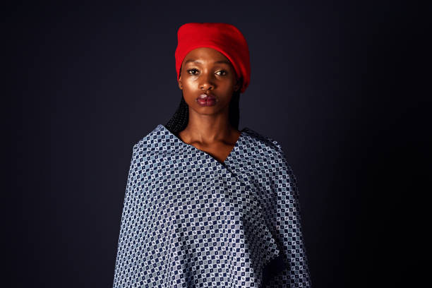 Culture is the fabric of a community Studio shot of an attractive young woman dressed in traditional african attire posing against a black background black shawl wrap stock pictures, royalty-free photos & images