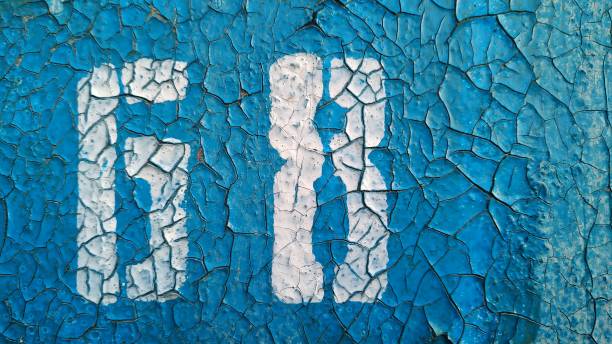 istock The number 68 with white paint on a cracked blue background. Close-up. 1168890378