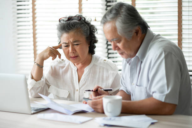 senior couple denken über ihre schulden. - senior adult couple computer retirement stock-fotos und bilder