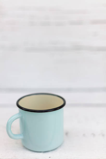 istock Enameled mugs in retro style on an old wooden background. 1168890762