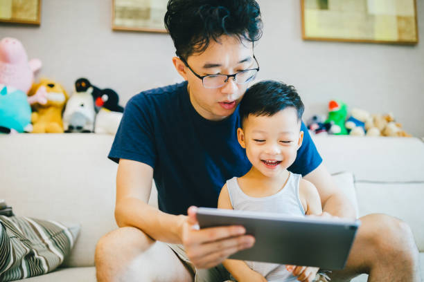 istock Asian father and son using digital table at home. 1168891581