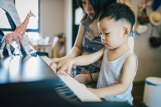 istock Chinese mother teaching her son how to play piano. 1168891636