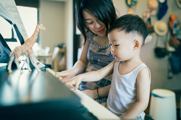 istock Chinese mother teaching her son how to play piano. 1168891668