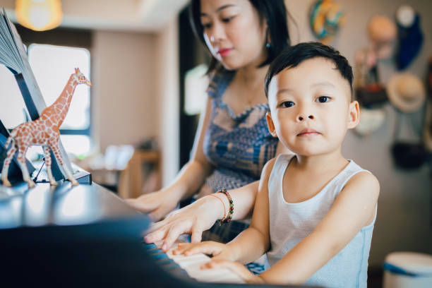 istock Chinese mother teaching her son how to play piano. 1168891688
