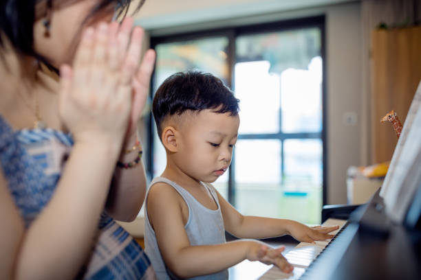 istock Chinese mother teaching her son how to play piano. 1168891691