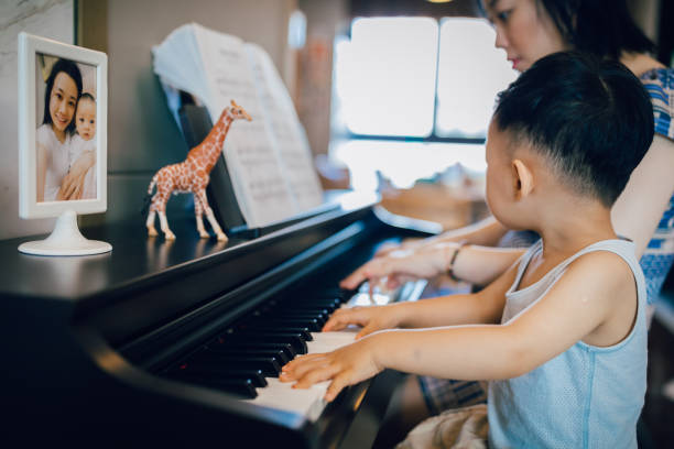 Chinese mother teaching her son how to play piano.