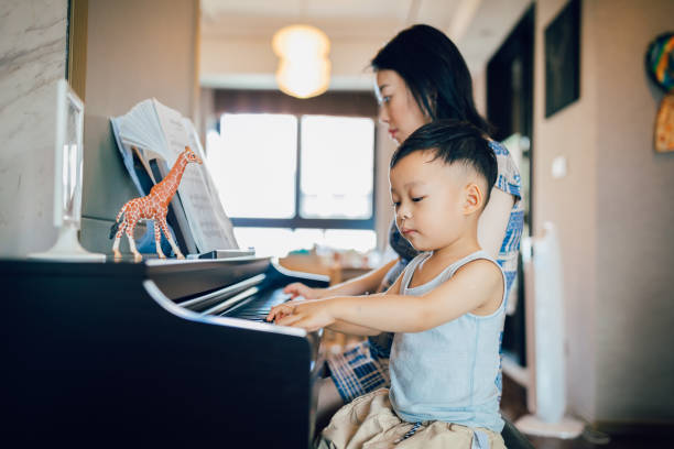 istock Chinese mother teaching her son how to play piano. 1168891713